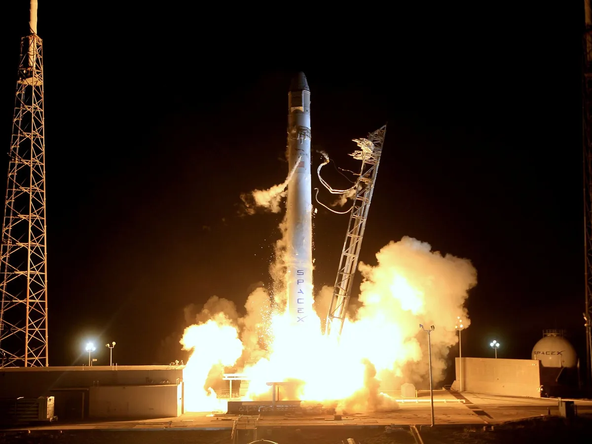 Rocket lifting off from a launch pad at night